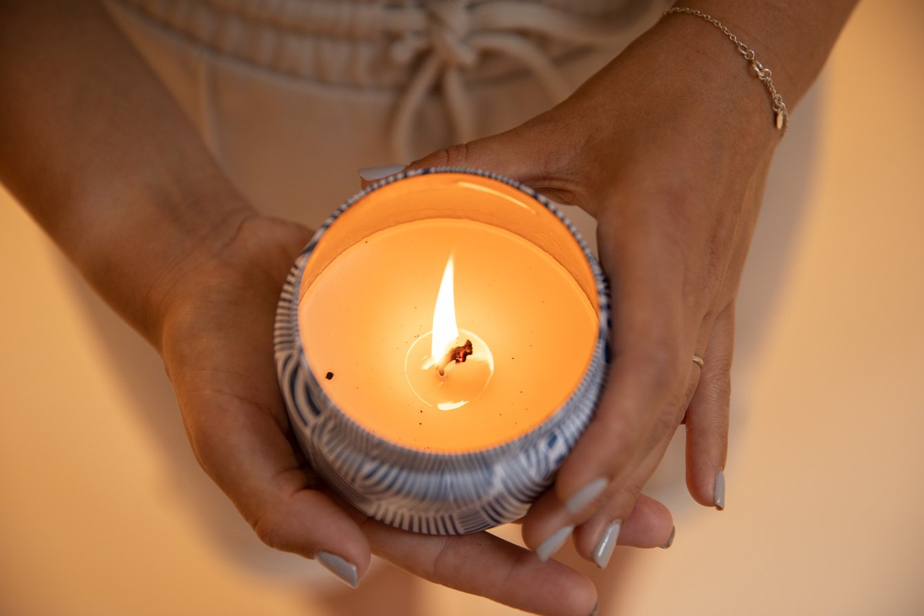Person Holding White Candle With Orange Candle